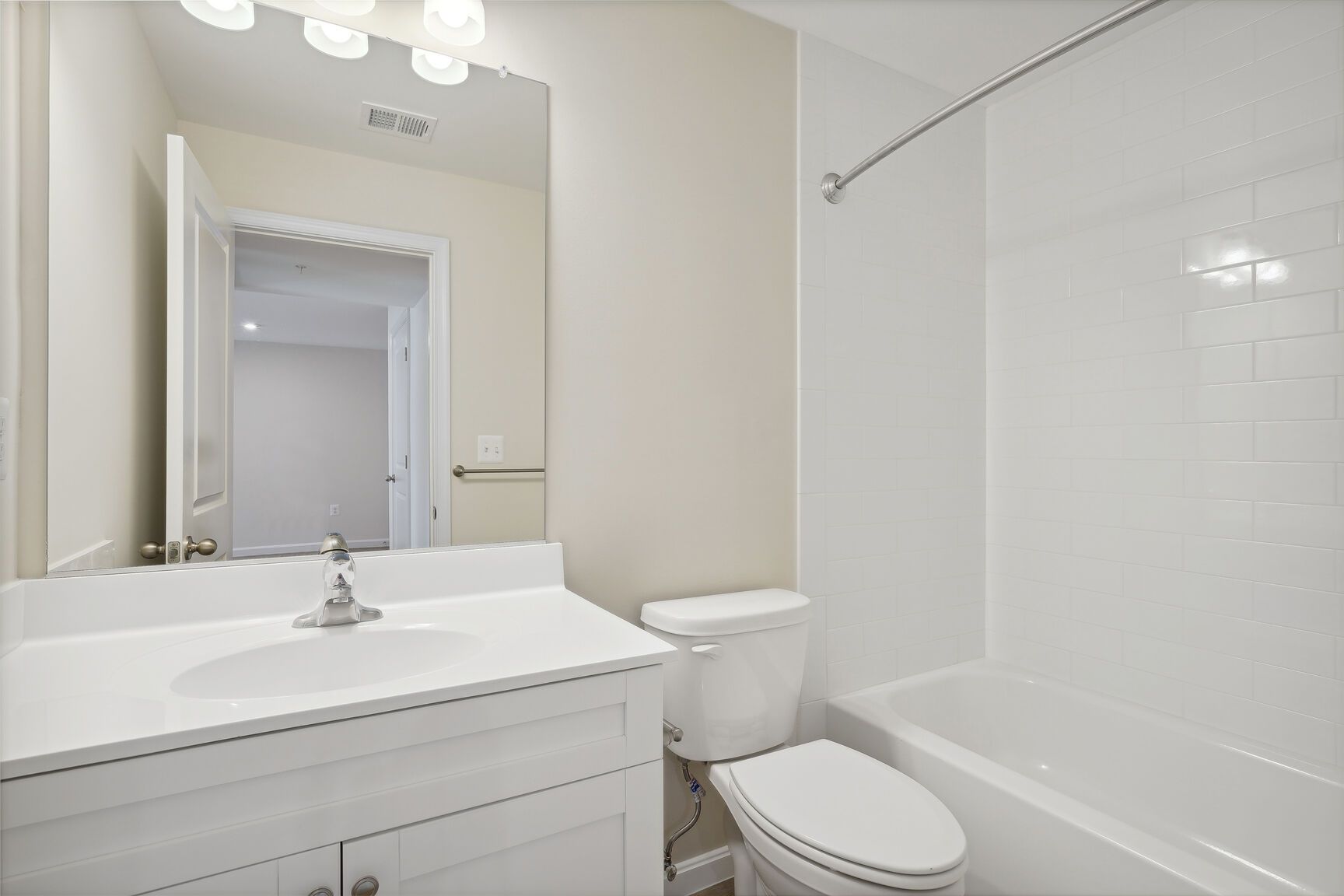 A bathroom with a sink , toilet , tub and mirror.