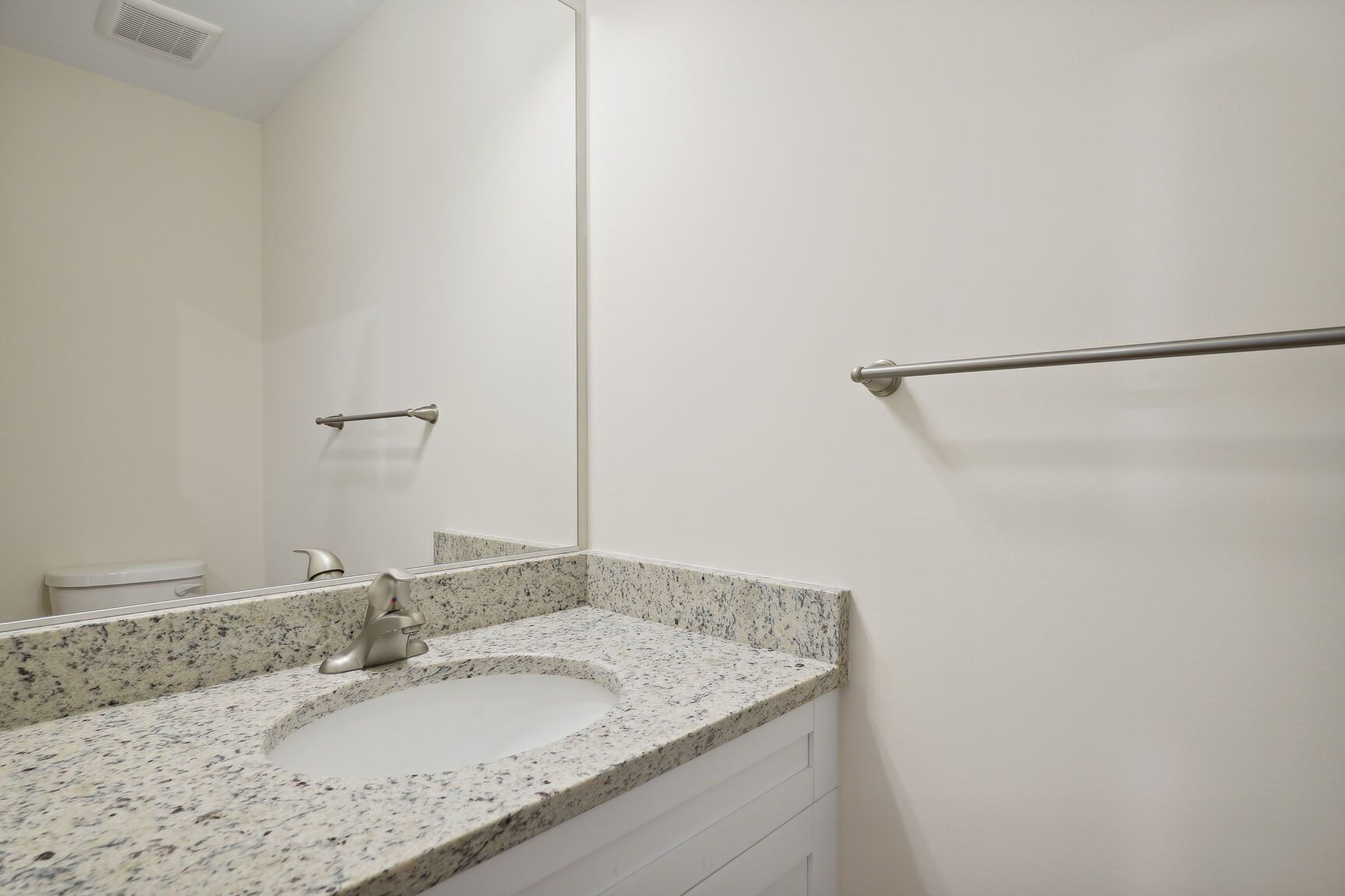 A bathroom with a sink , toilet and mirror.