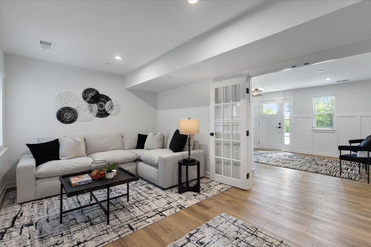 A living room with a couch , coffee table , and chairs.