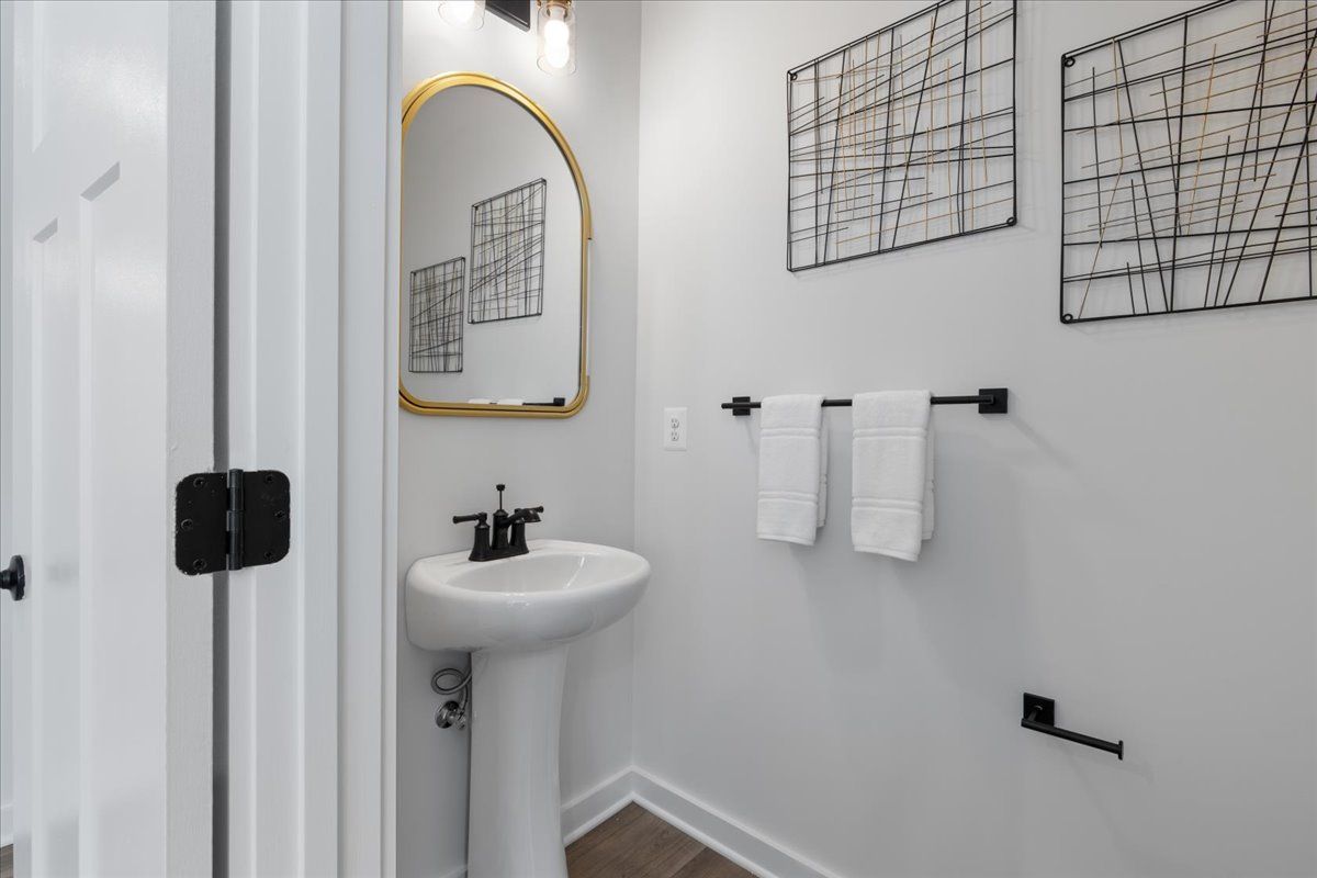 A bathroom with a sink , mirror and towel rack.