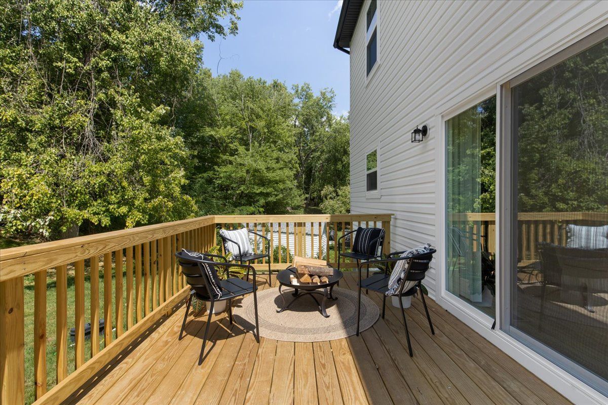 There is a wooden deck with a table and chairs on it.
