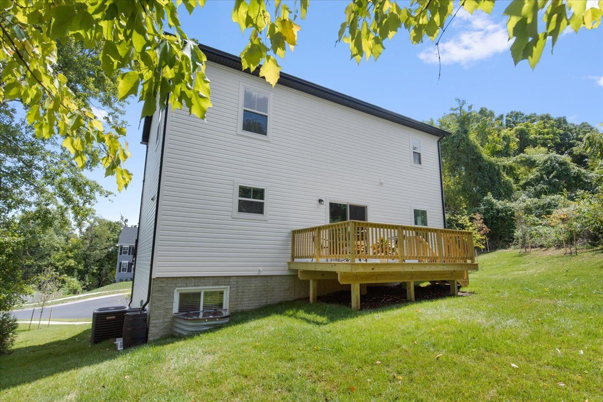 A white house with a wooden deck in the backyard