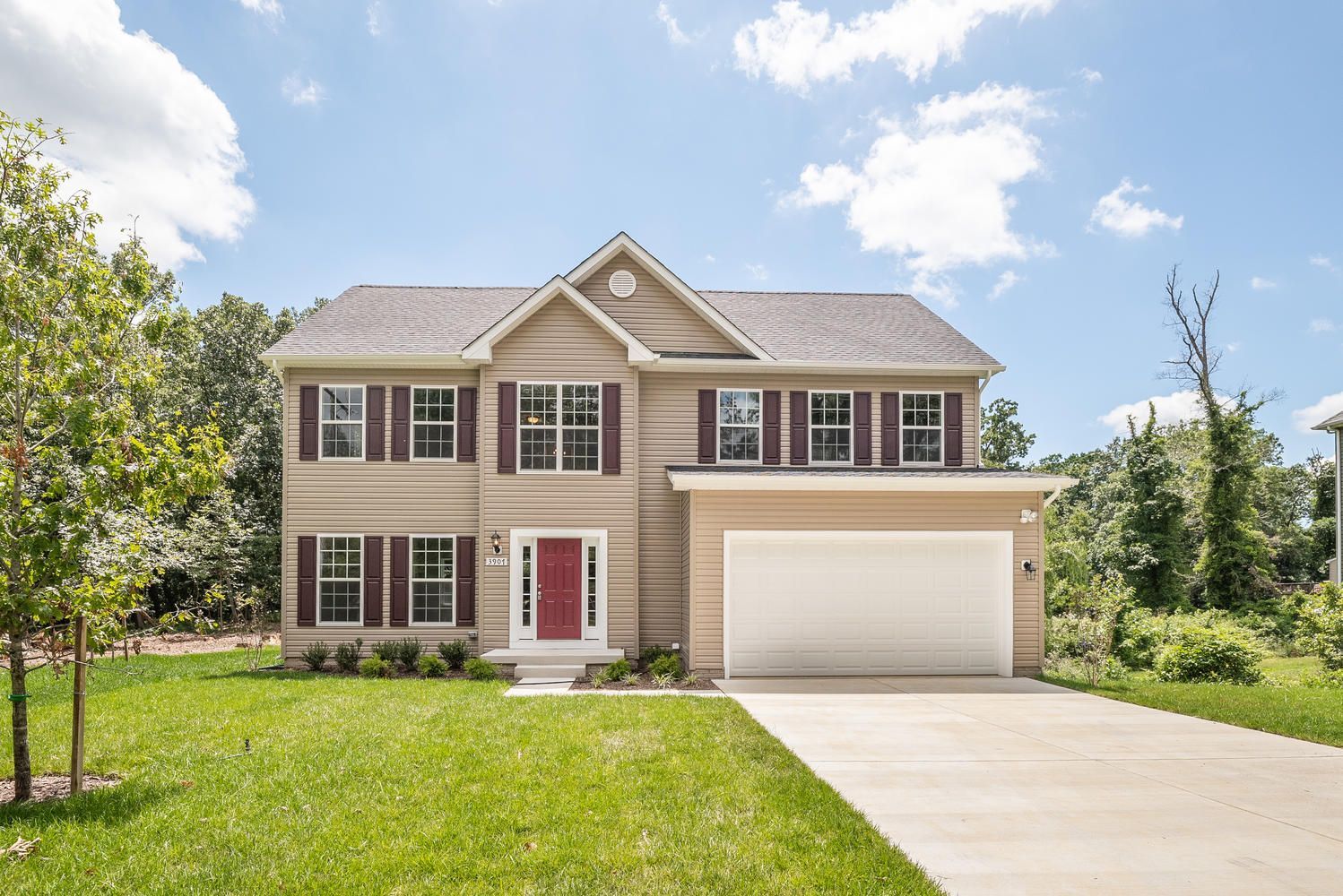 A large house with a white garage door and a red door.