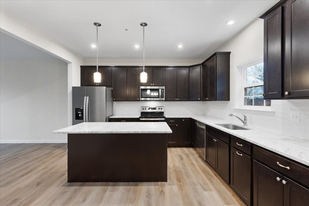 A kitchen with a large island and stainless steel appliances