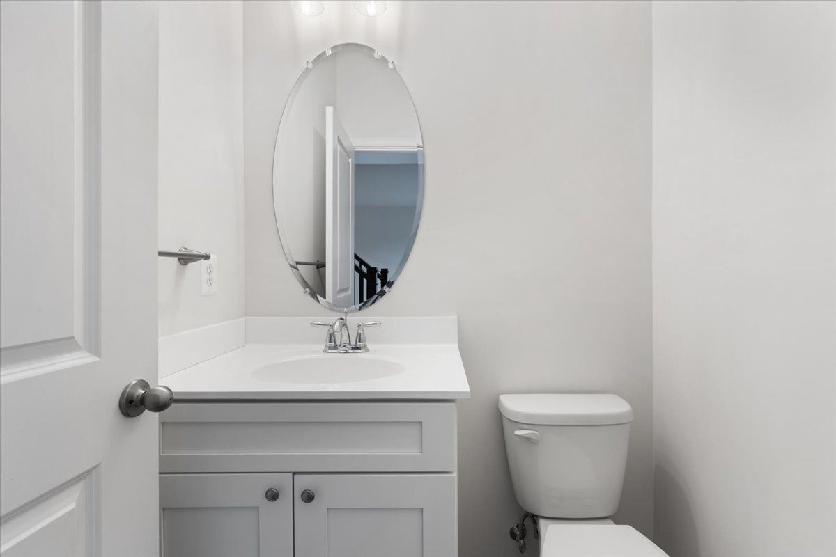 A bathroom with a sink , toilet and mirror.