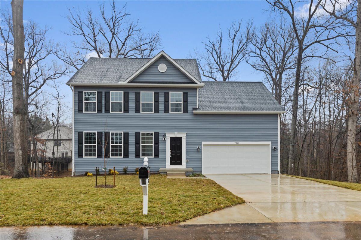 A large house with a driveway and a mailbox in front of it.