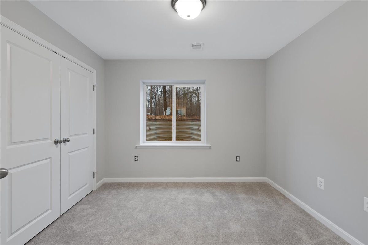 An empty room with a window and a sliding glass door