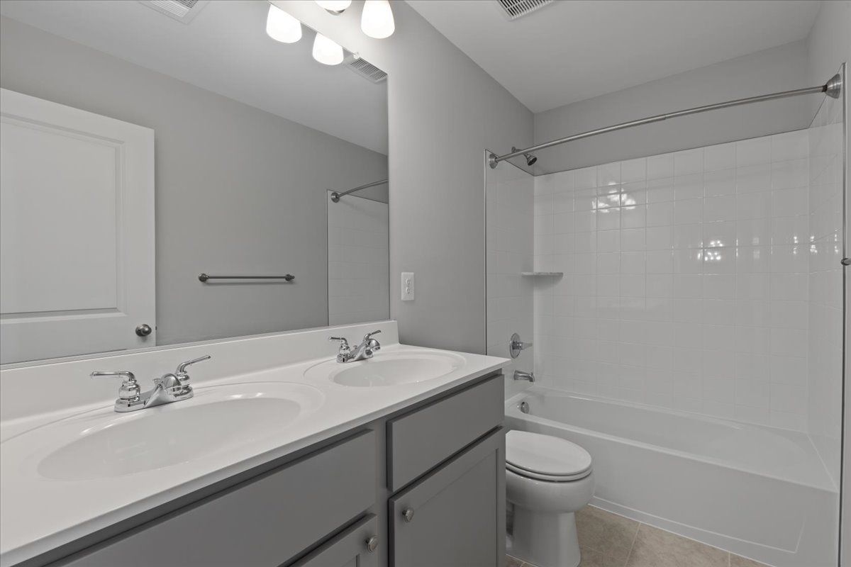 A bathroom with two sinks , a toilet , and a bathtub.