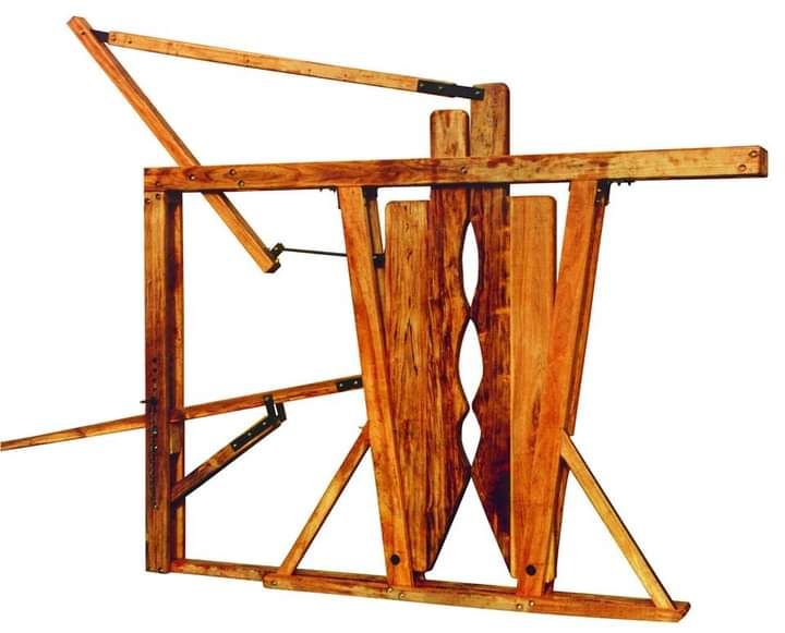 Dispositivo de tortura de madera, probablemente un potro, con postes verticales, palancas y una estructura central