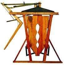 Máquina de asedio medieval de madera con escudo, marrón y negro.