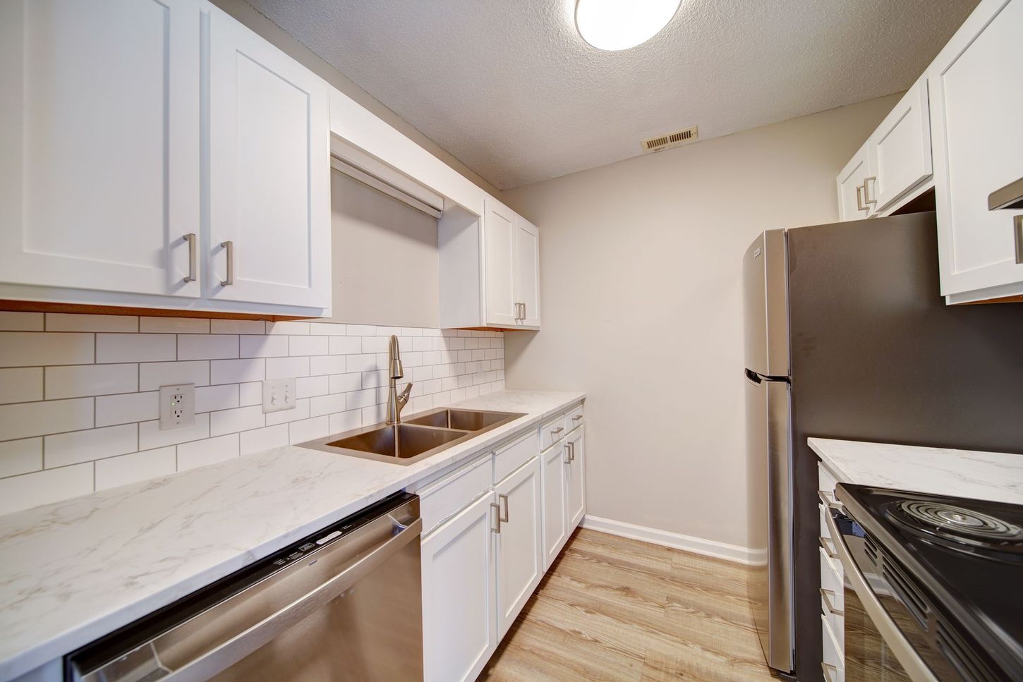 A kitchen with white cabinets and stainless steel appliances