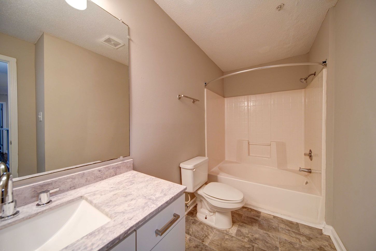 A bathroom with a toilet , sink , and bathtub.