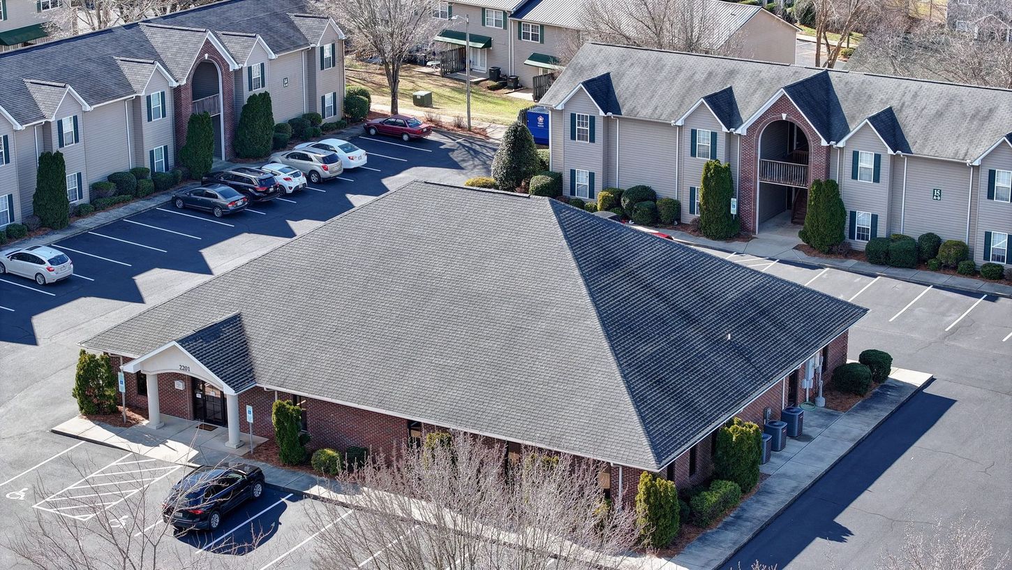 An aerial view of a building with cars parked in front of it