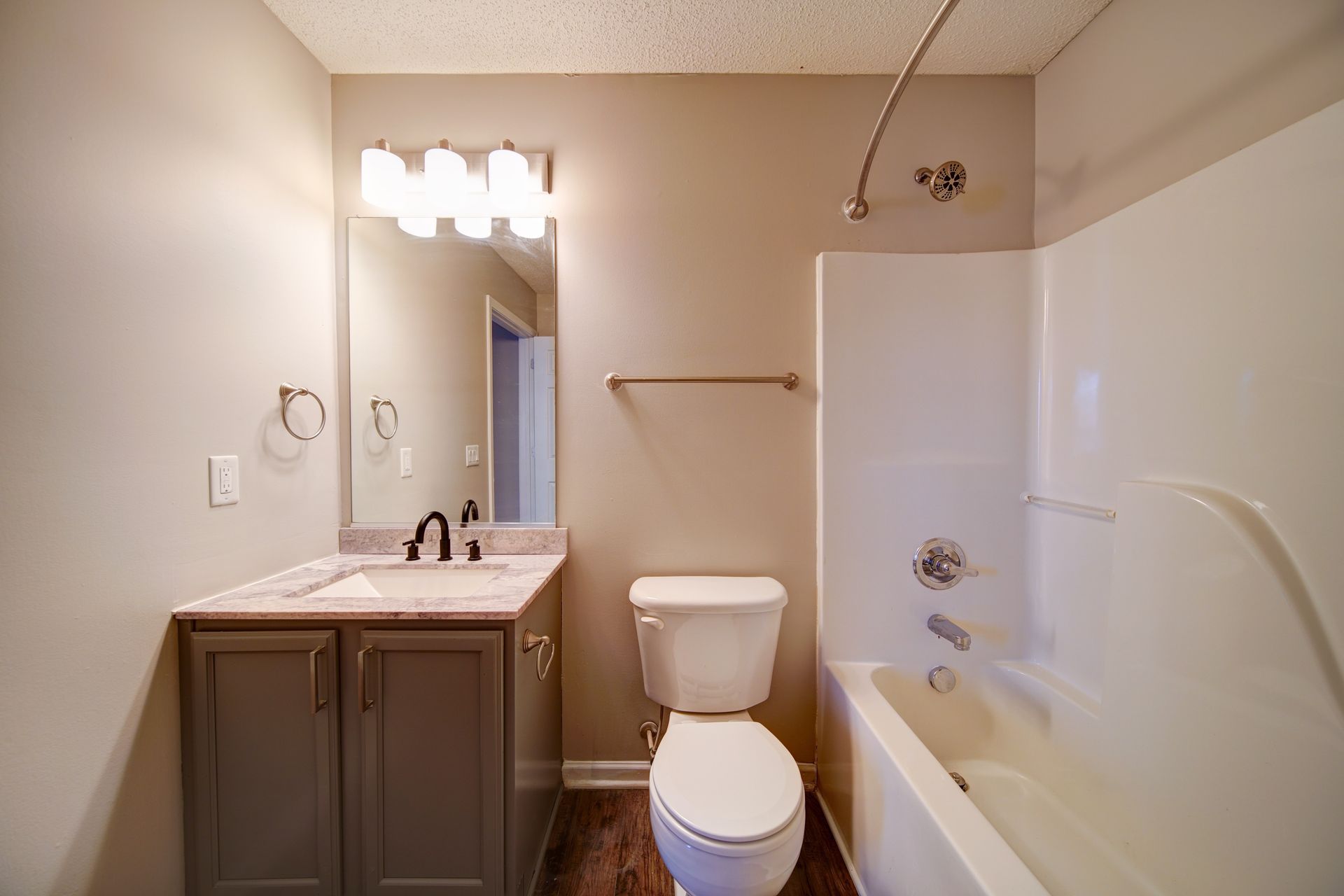 A bathroom with a toilet , sink , and bathtub.