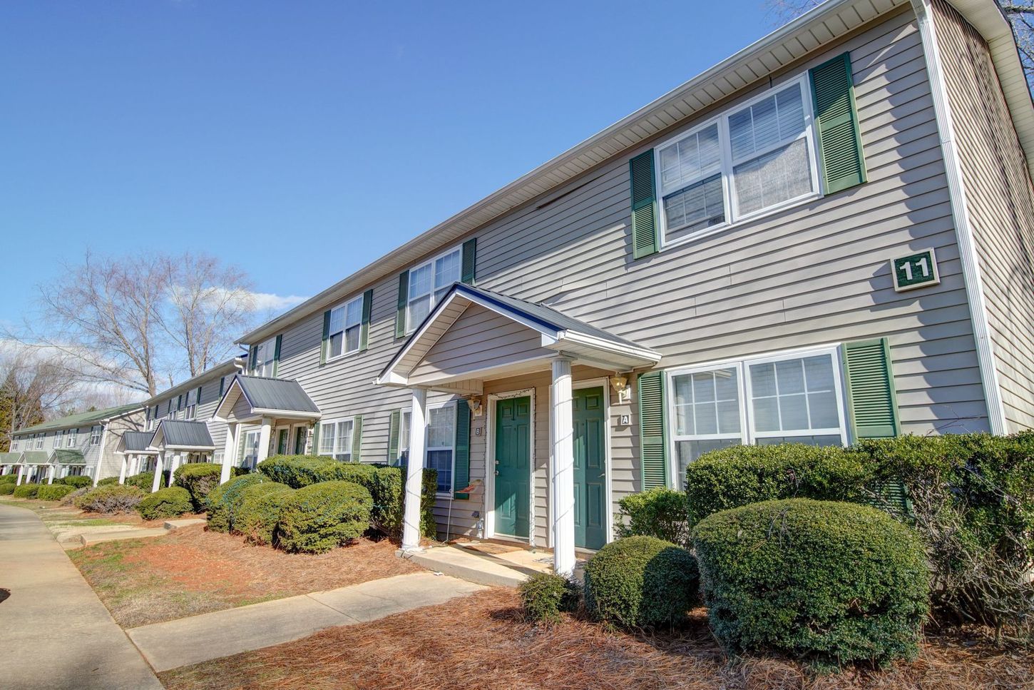 A row of apartment buildings with green shutters on the windows