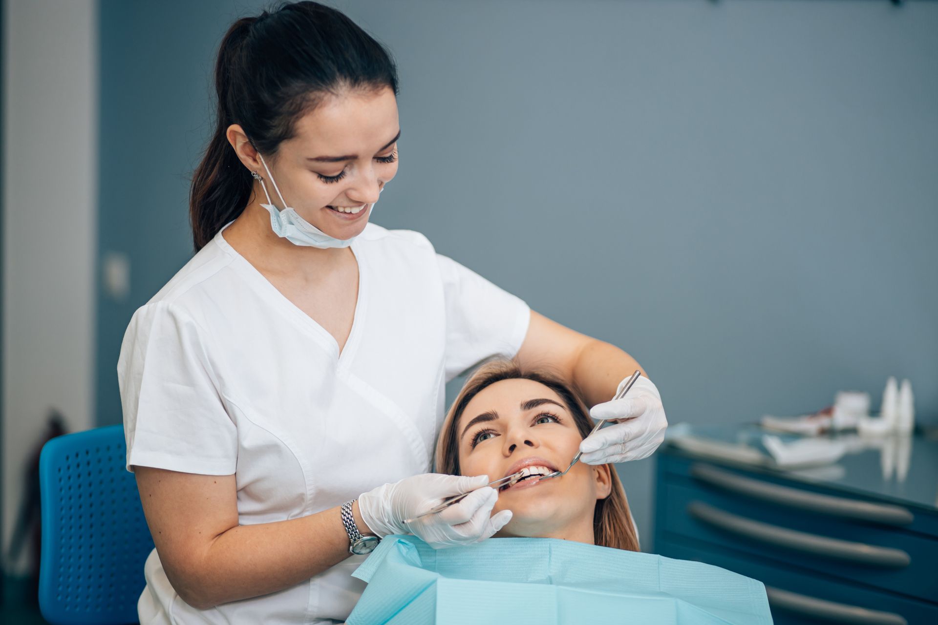 A friendly woman dentist treating a beautiful patient in a dental office.