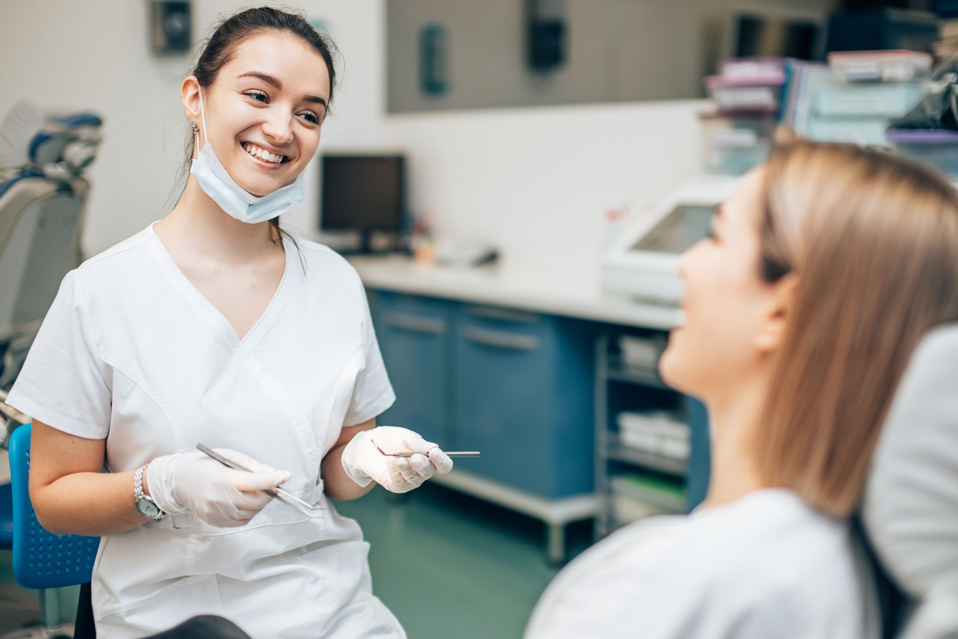 Dental hygienist holding instruments during oral checkup in modern dental clinic. Dental hygienist holding instruments during oral checkup in modern dental clinic.