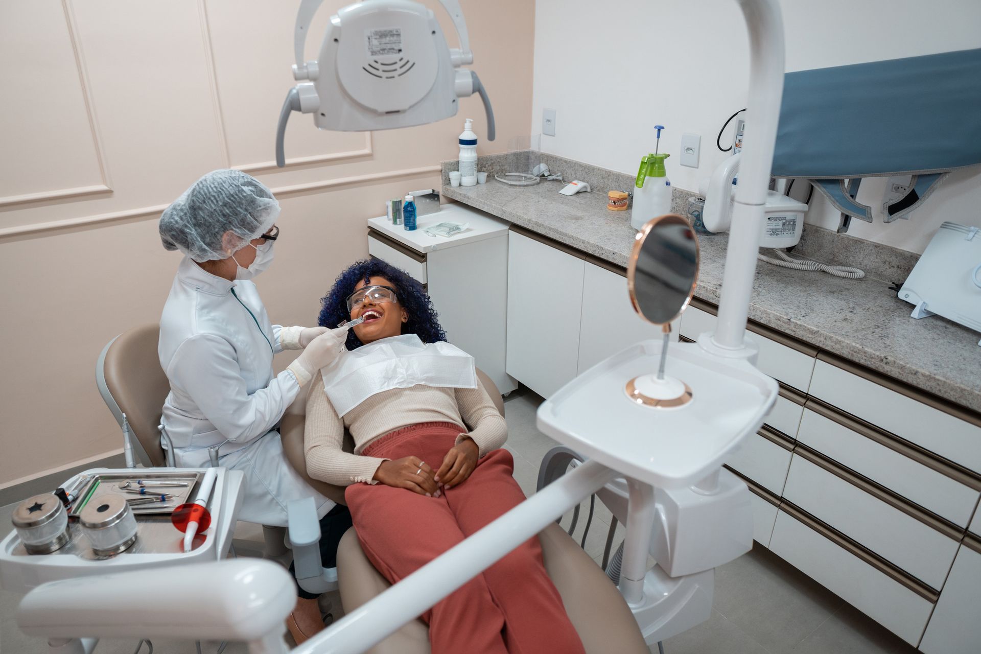 A dentist treats a patient in the clinic with dental tools around.