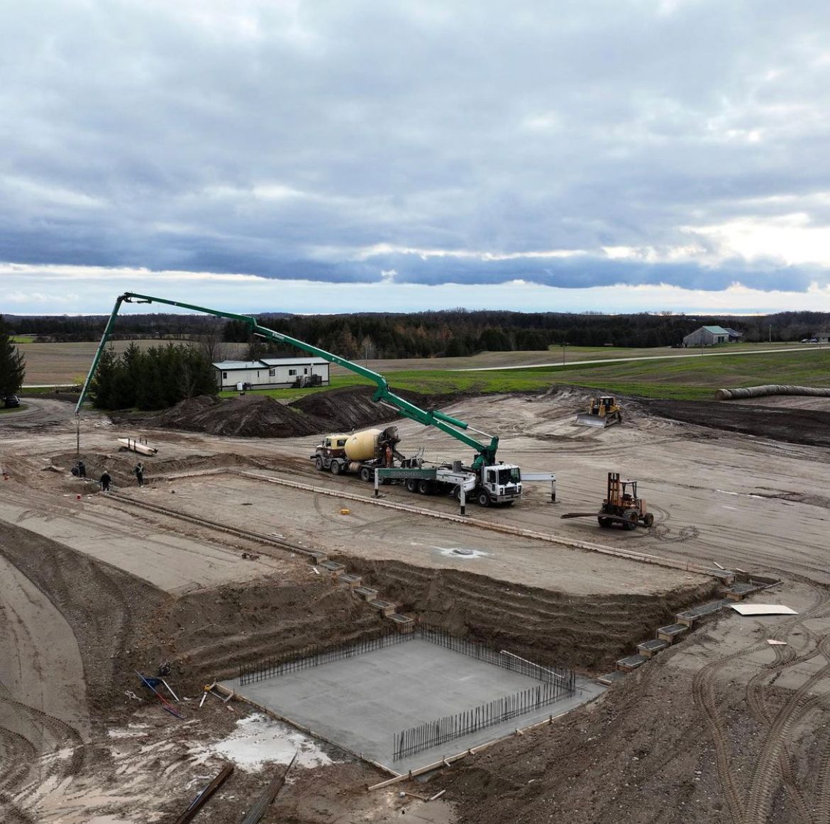 An aerial view of a construction site with a green crane.
