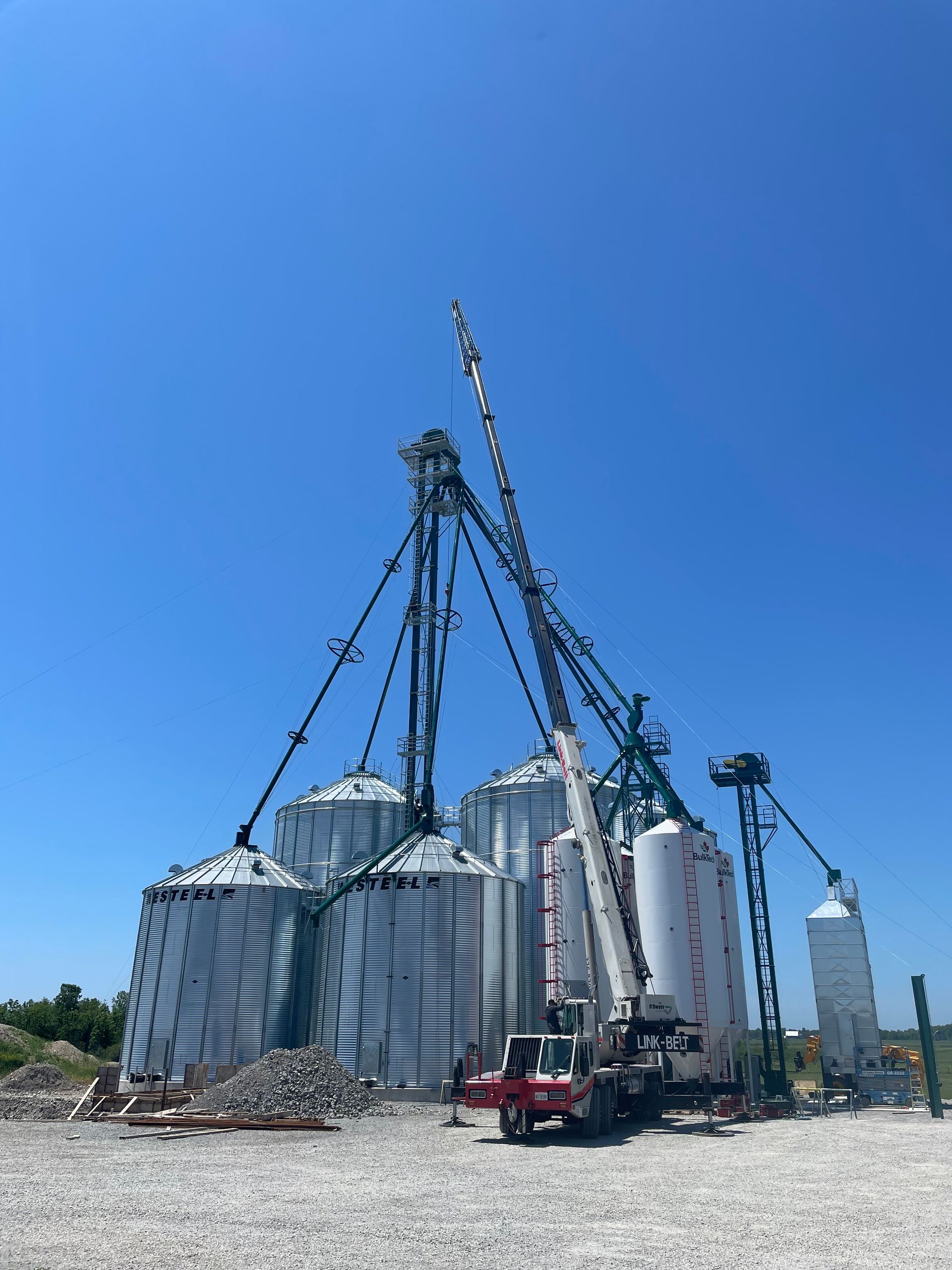 A crane is sitting in front of a large building.