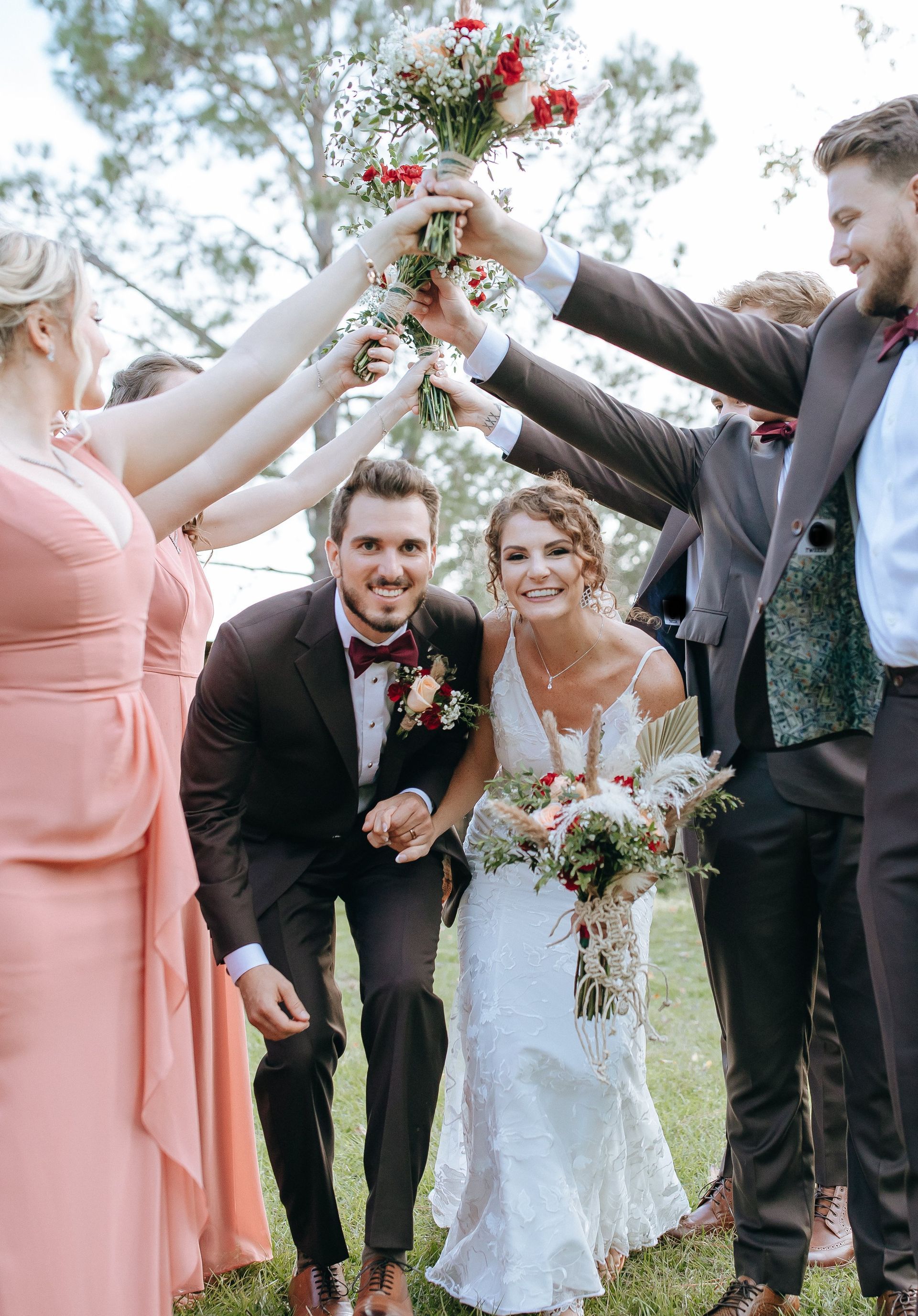 A bride and groom are posing for a picture with their wedding party.