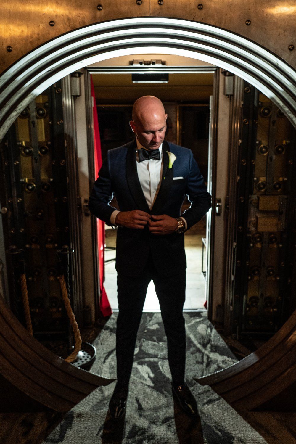A man in a suit and bow tie is standing in a doorway.