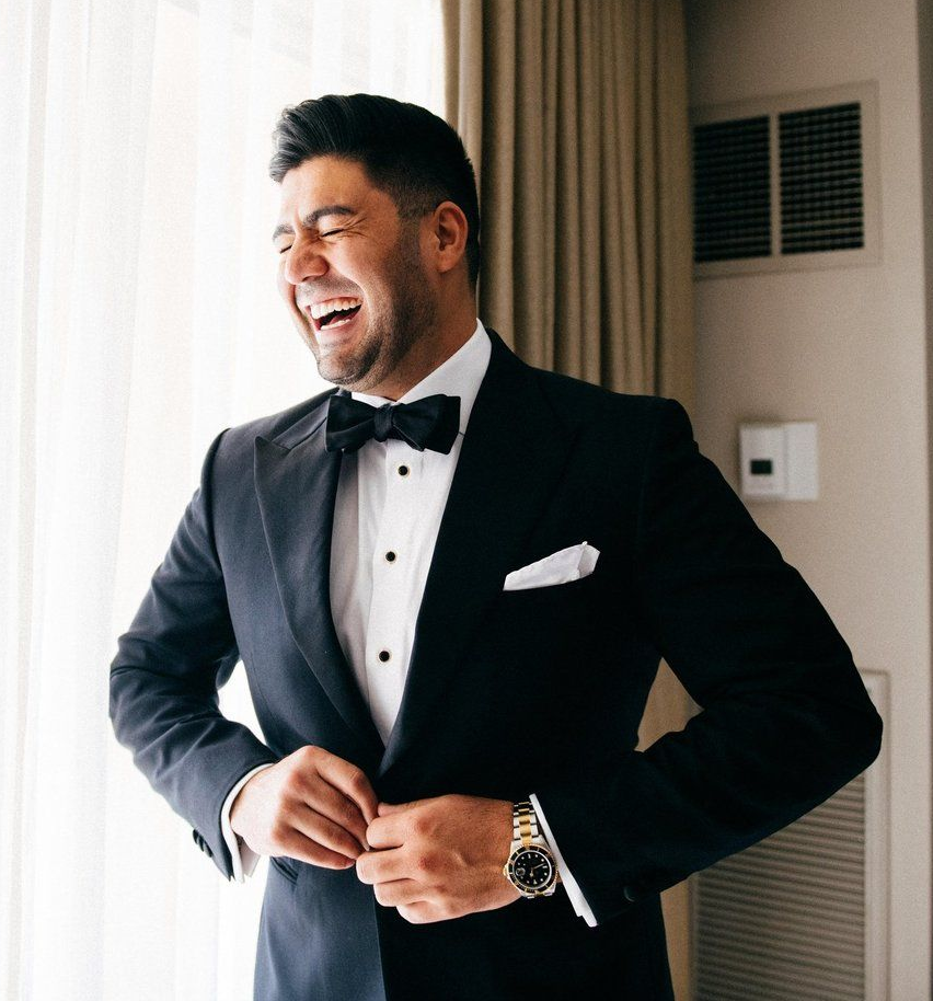 A group of men in suits and ties are toasting with wine glasses.