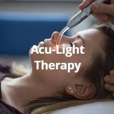 Woman receiving acu-light therapy on her face. A device emits red light.