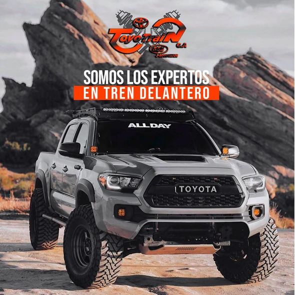 Camioneta Toyota gris con modificaciones, en un paisaje desértico. Texto: Expertos en suspensión delantera.