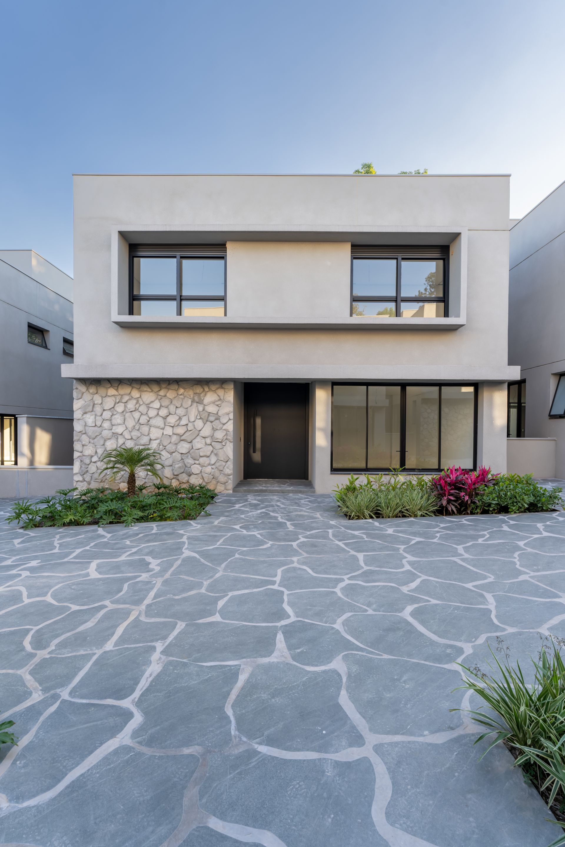 Uma casa moderna com uma entrada de pedra na frente