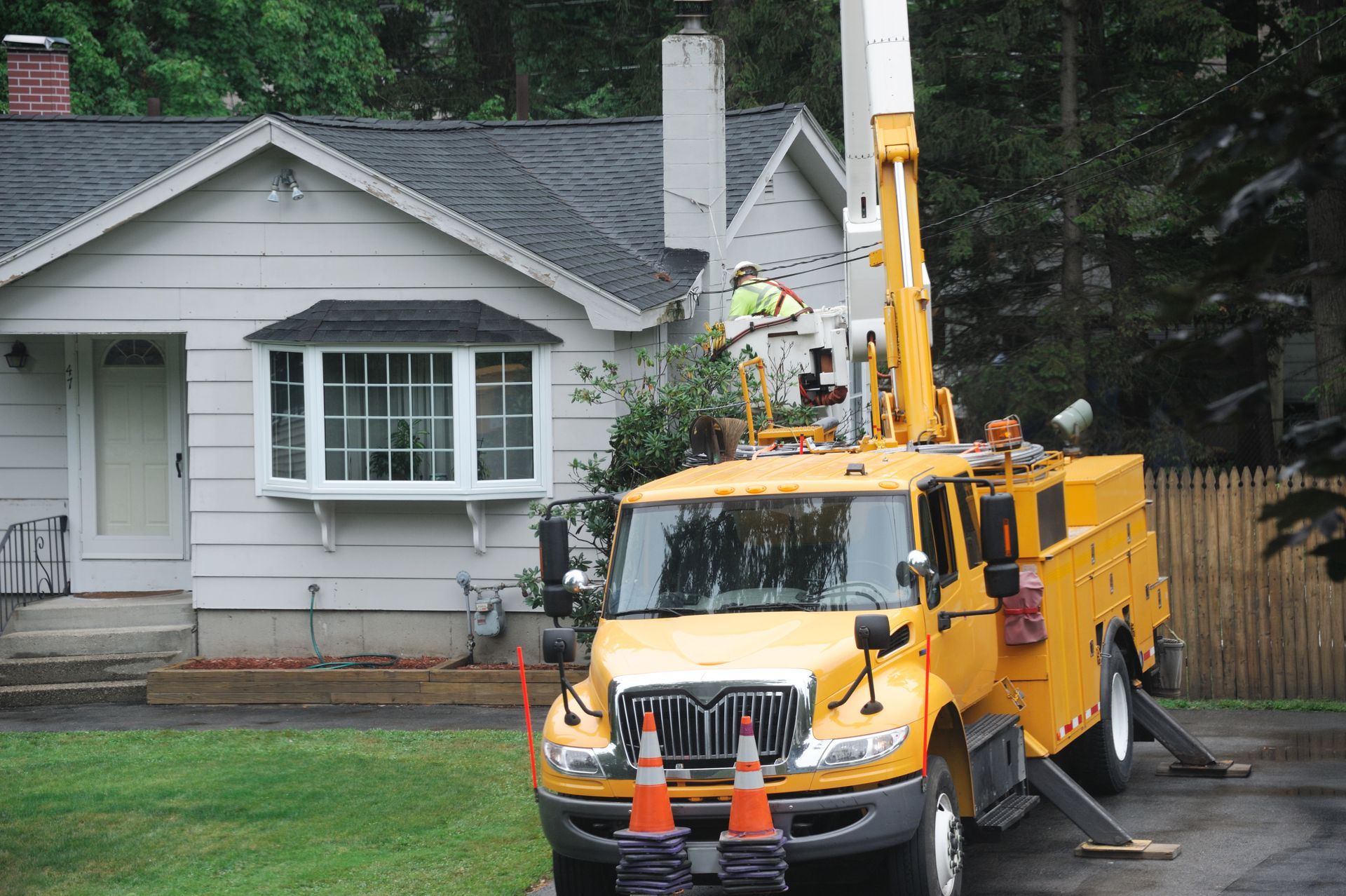 A yellow truck is parked in front of a house
