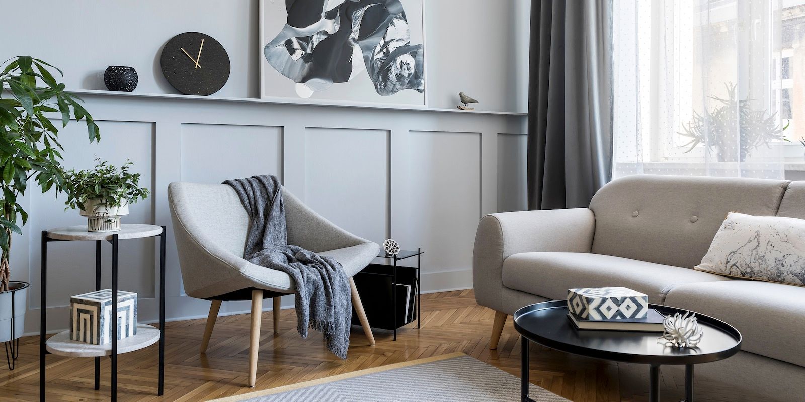 Cozy living room with gray walls, sofa, chair, and black oval coffee table.