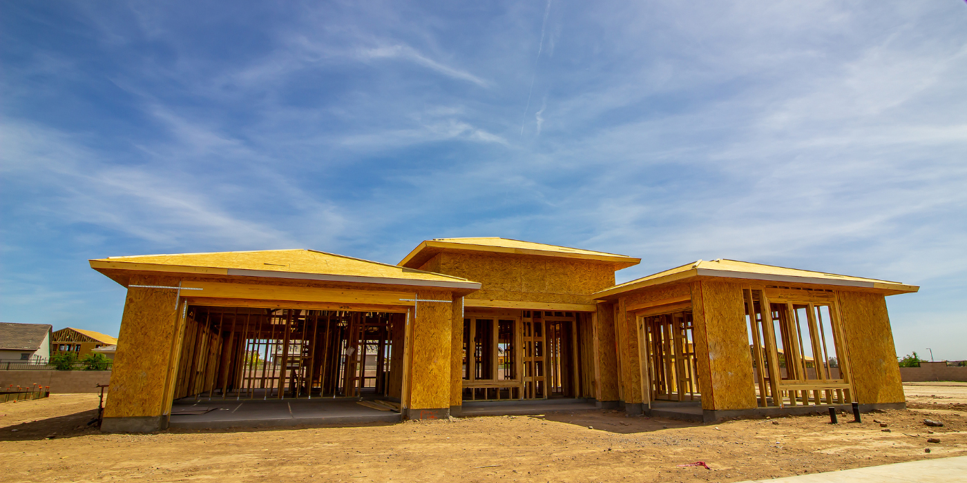 A house under construction. Wooden frame against a blue sky.