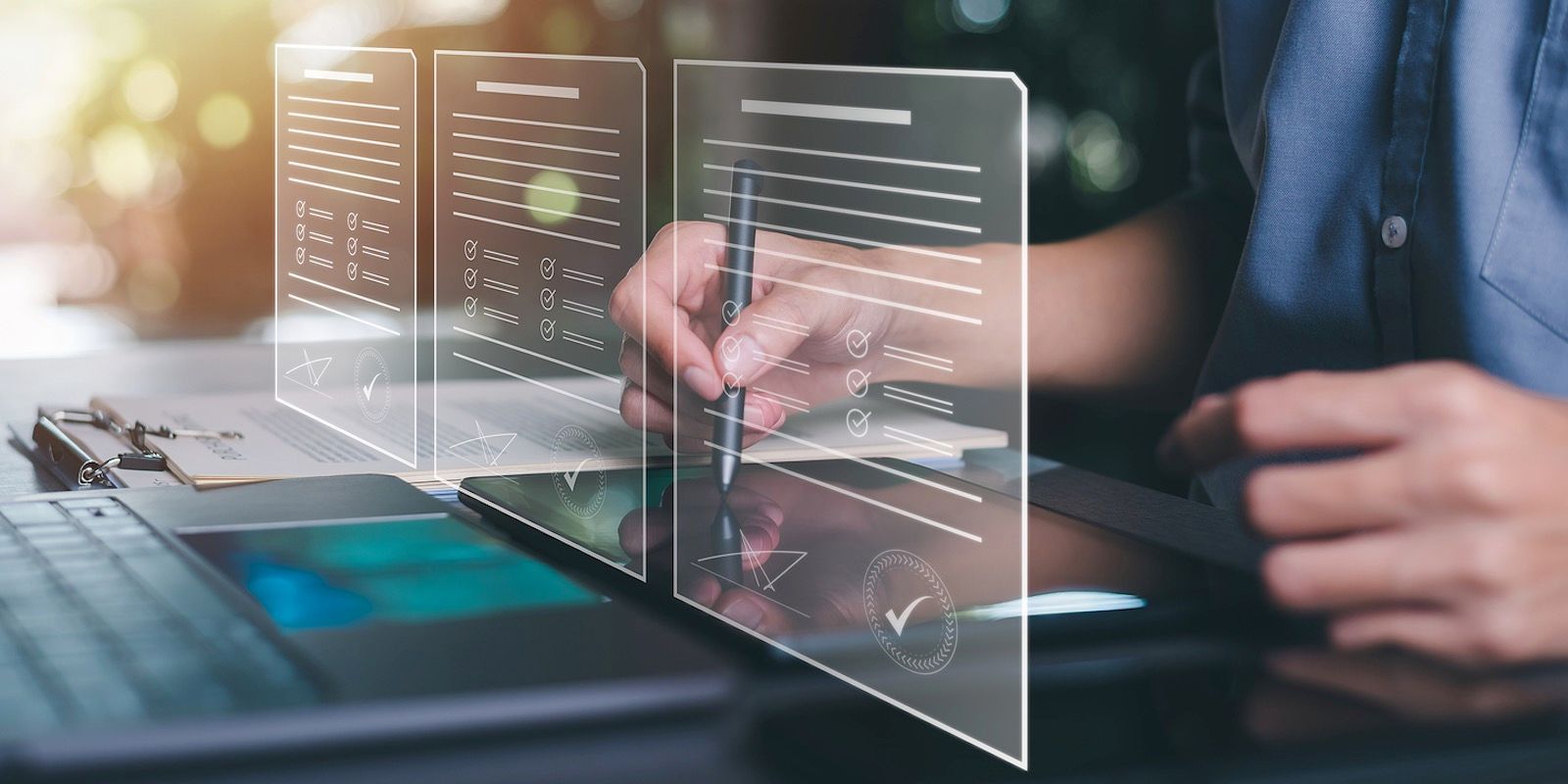 Person signing a document on a digital tablet, with a laptop in the foreground, indicating e-signature.