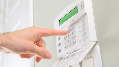Une personne appuie sur un bouton d'un système de sécurité.
