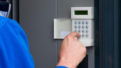 Une personne appuie sur un bouton d'un système de sécurité.