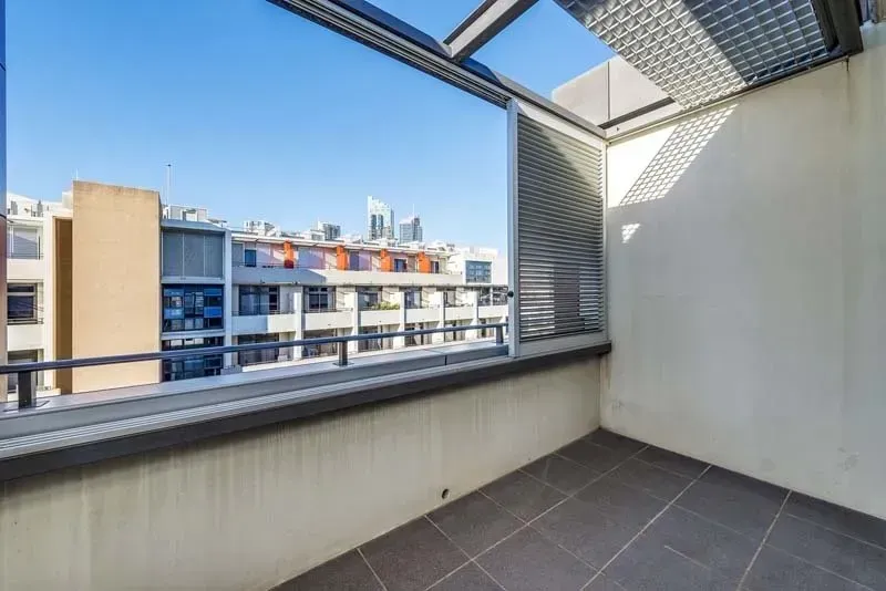 Balcony with city view, gray tile floor, neutral walls, metal railing.