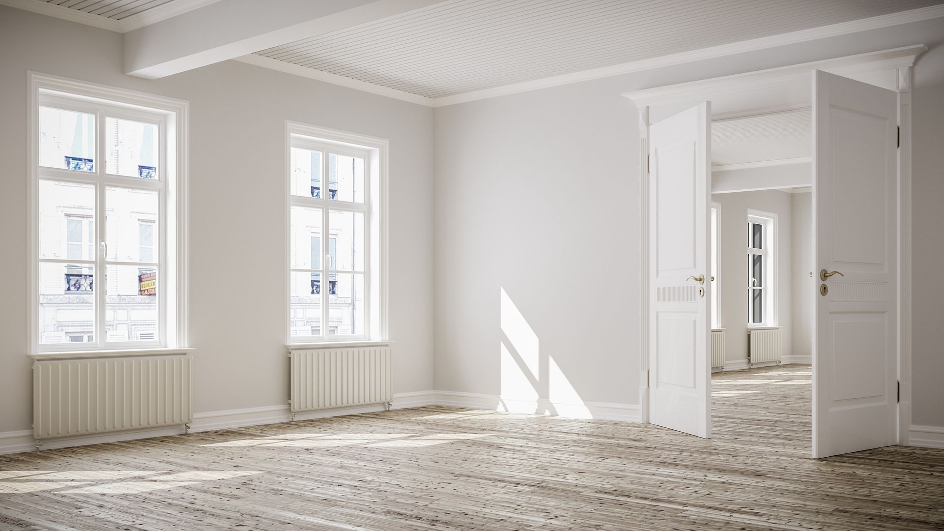 Empty, bright white room with three windows, a partially open door, and textured floor.