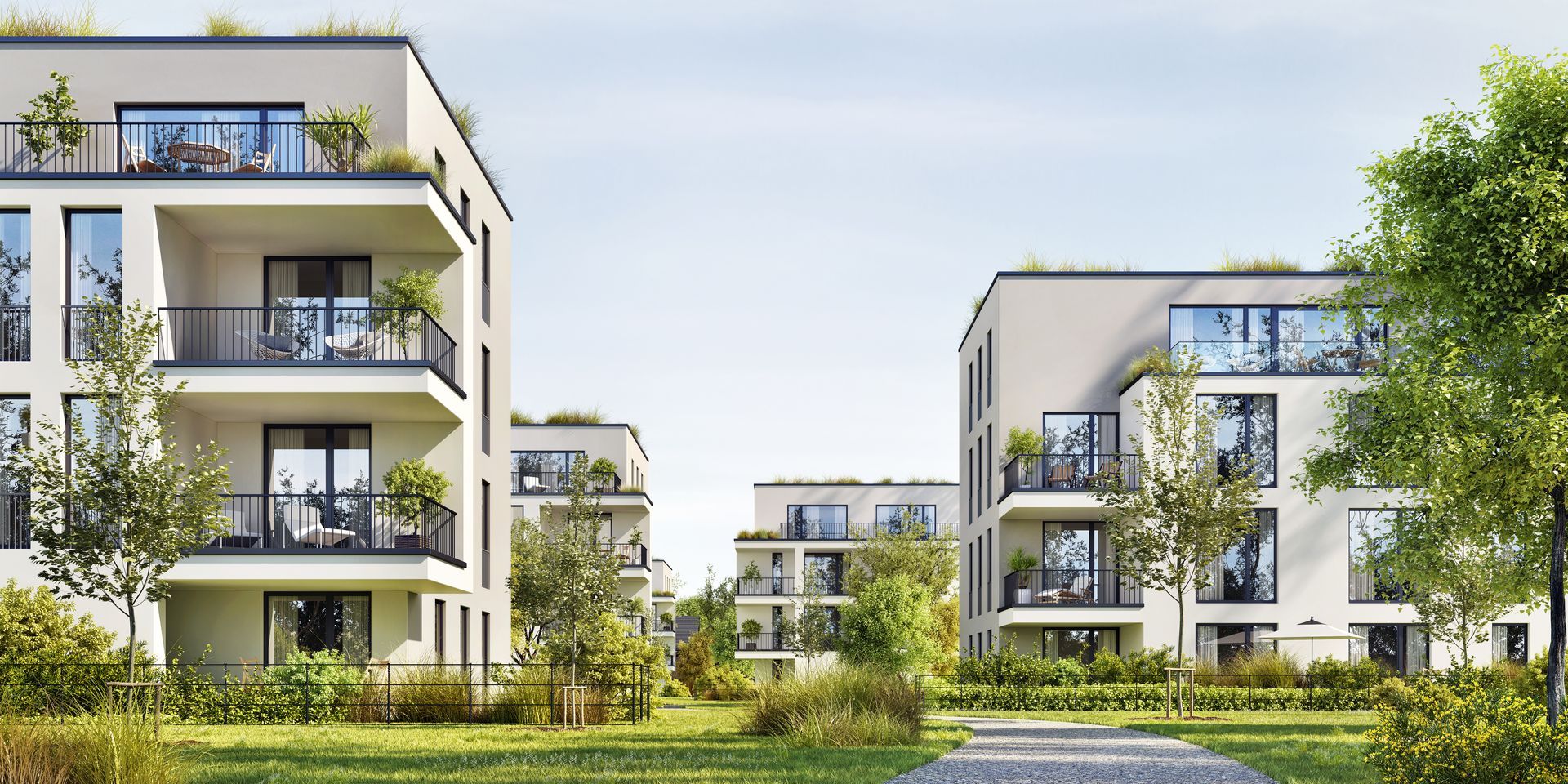 Modern apartment buildings with balconies, green roofs, and lush landscaping.