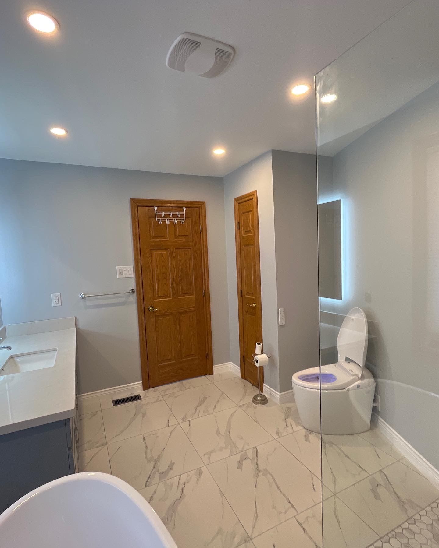 A bathroom with a toilet , sink , and walk in shower.