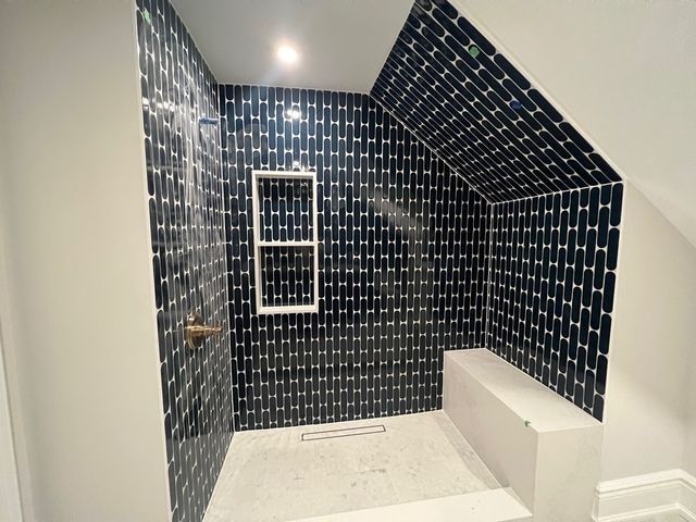 A bathroom with blue tiles and a walk in shower