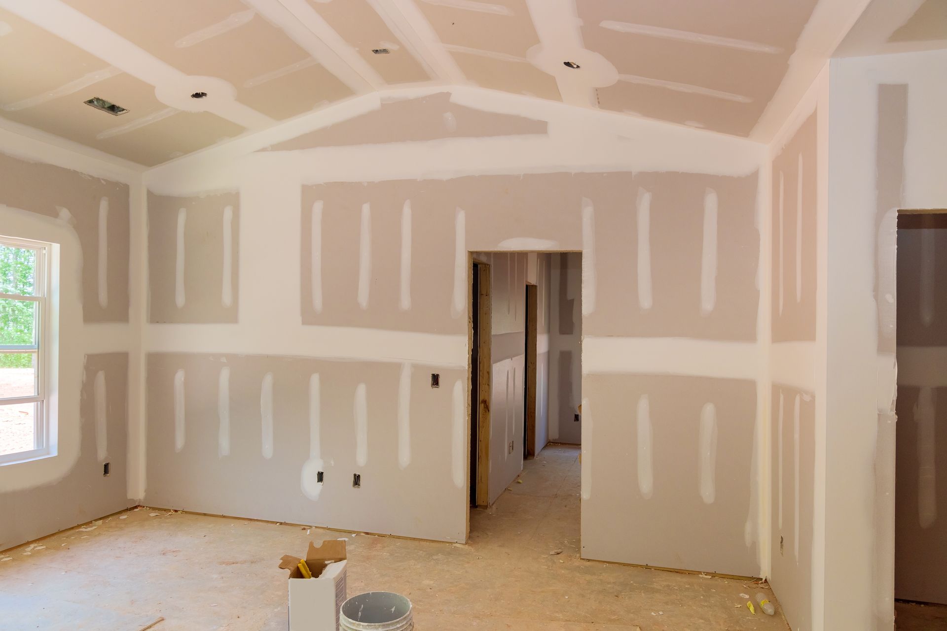 An empty room with drywall on the walls and ceiling.