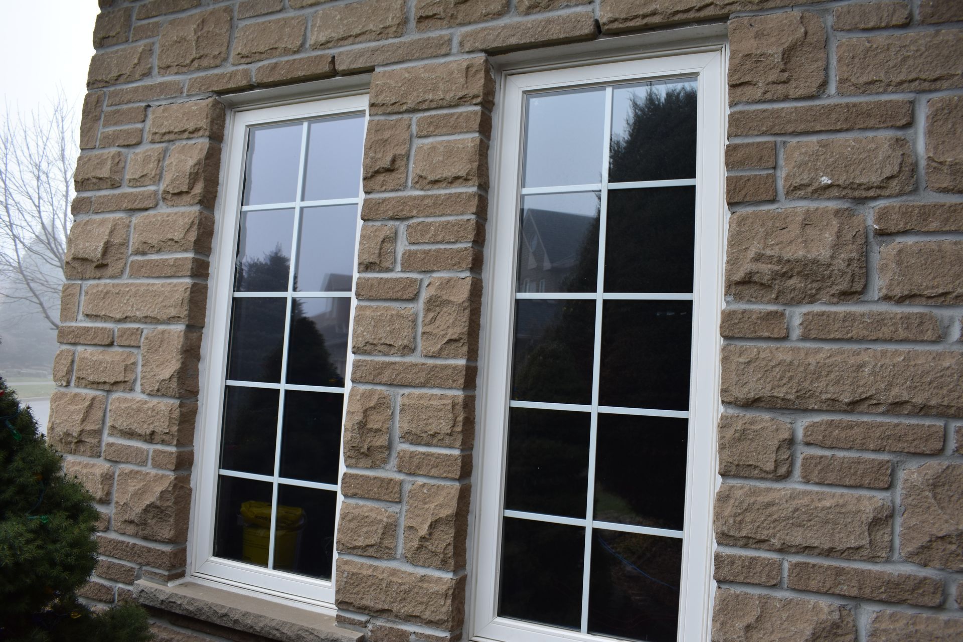 Two windows on the side of a brick building