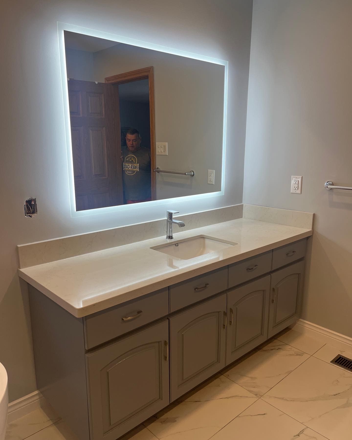 A bathroom with a sink , mirror and cabinets.