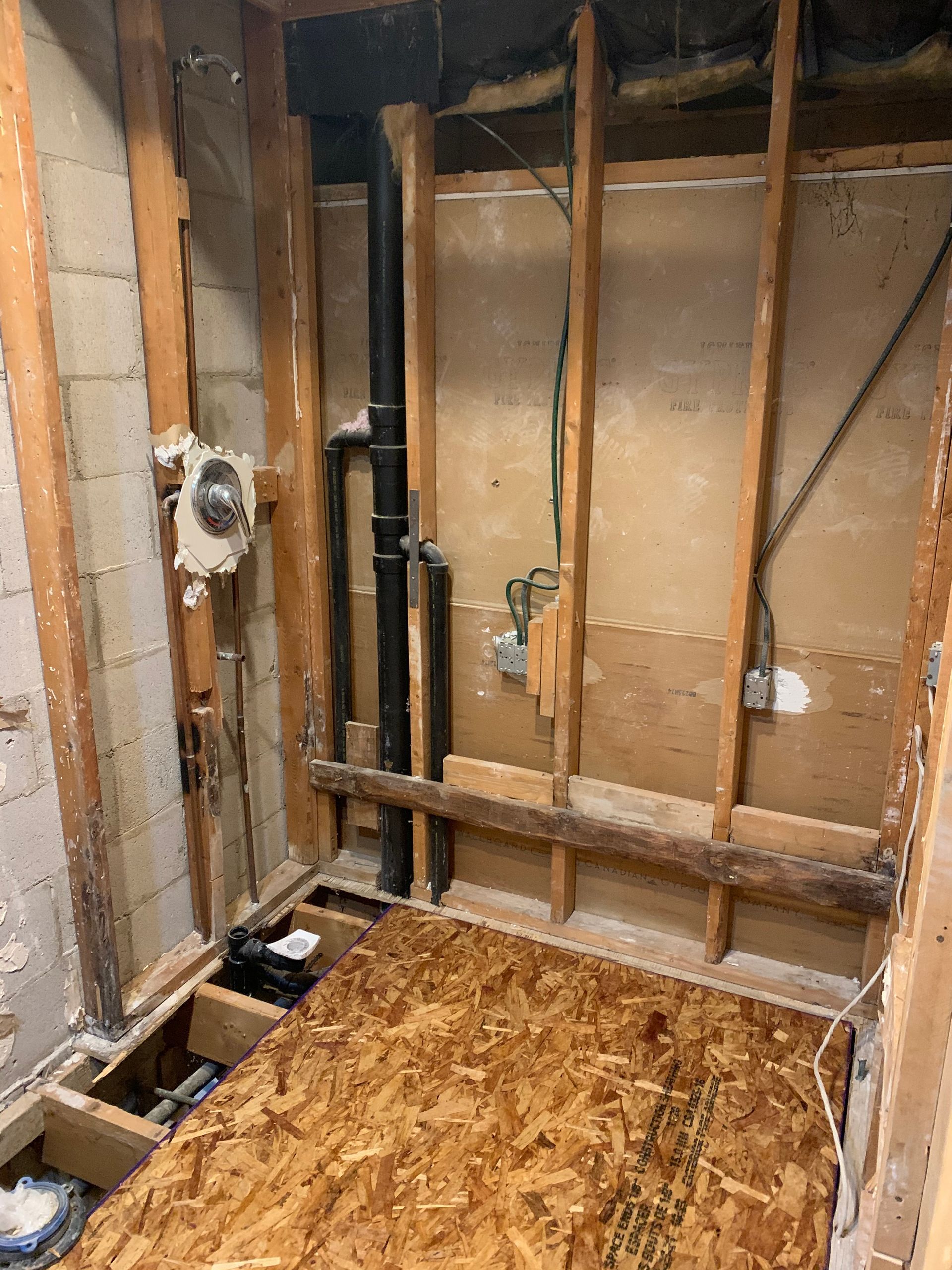 A bathroom under construction with wooden beams and a wooden floor.