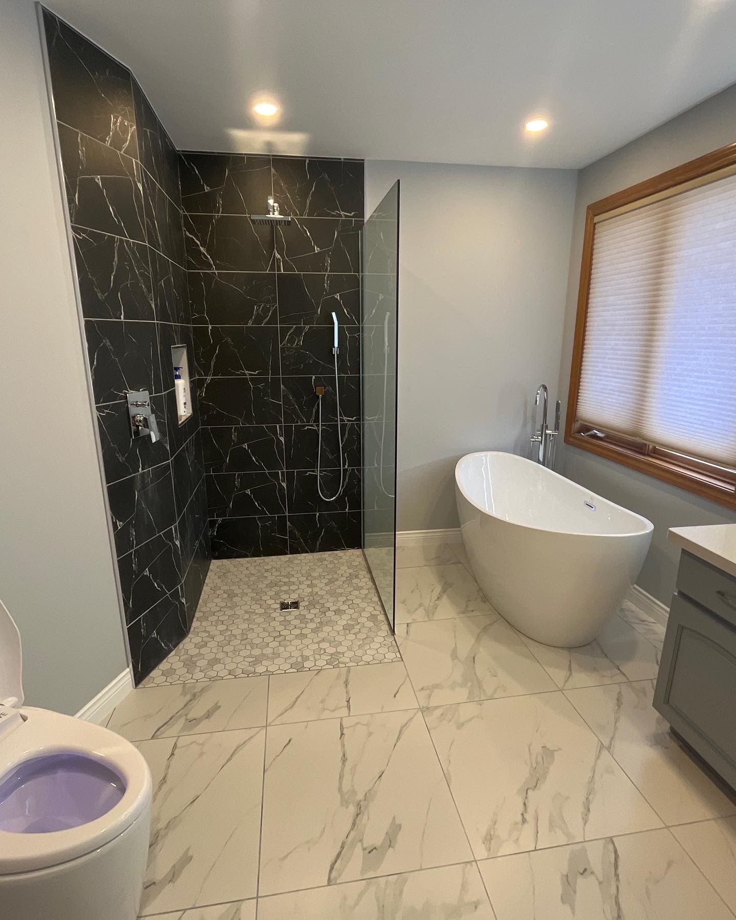 A bathroom with a tub , toilet and shower.