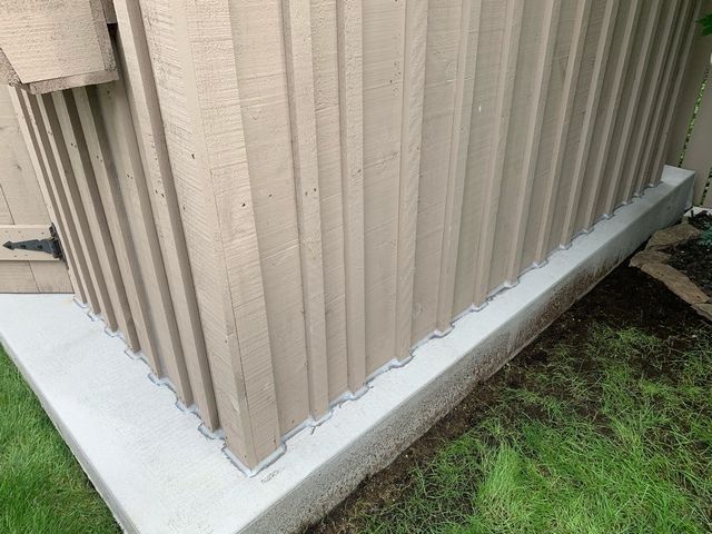 A close up of a shed with a concrete foundation.