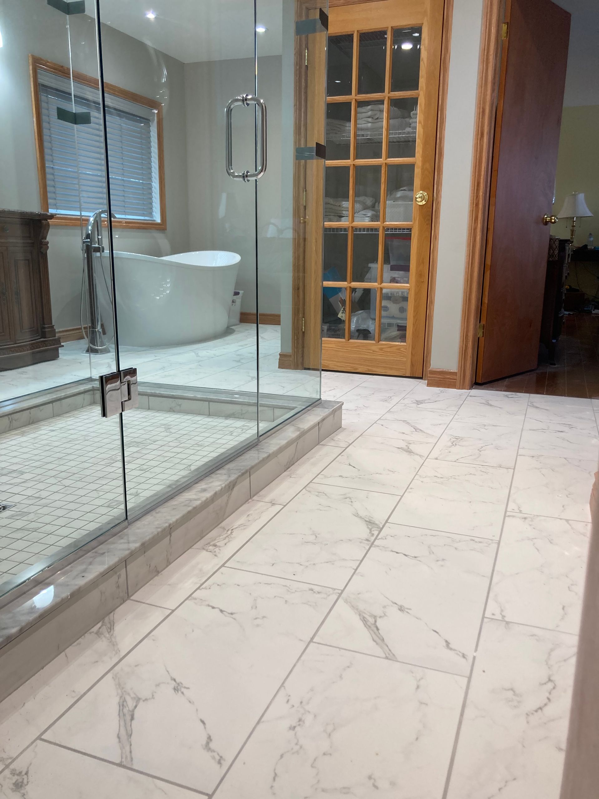 A bathroom with a bathtub and a glass door