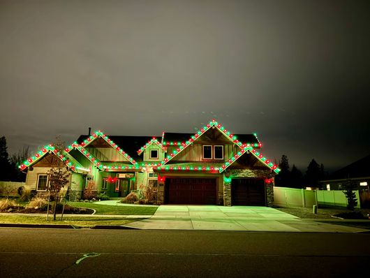 A house decorated with green and red christmas lights