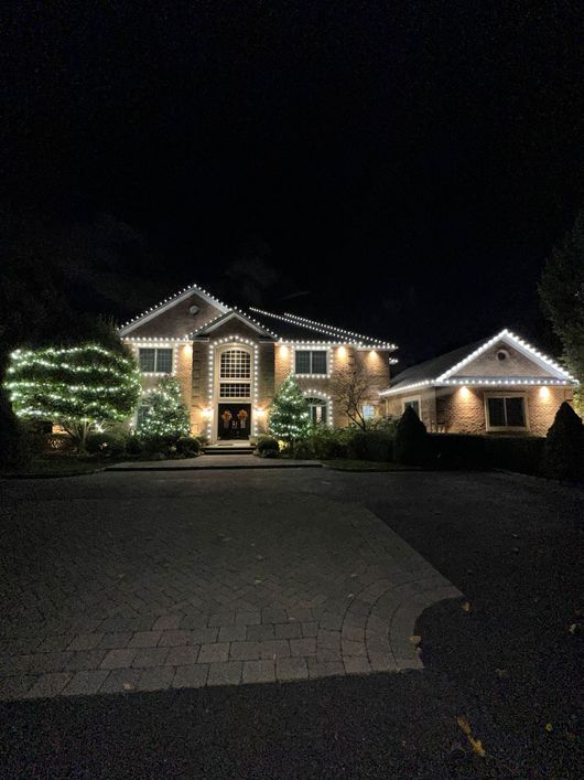 A large house is lit up with christmas lights at night